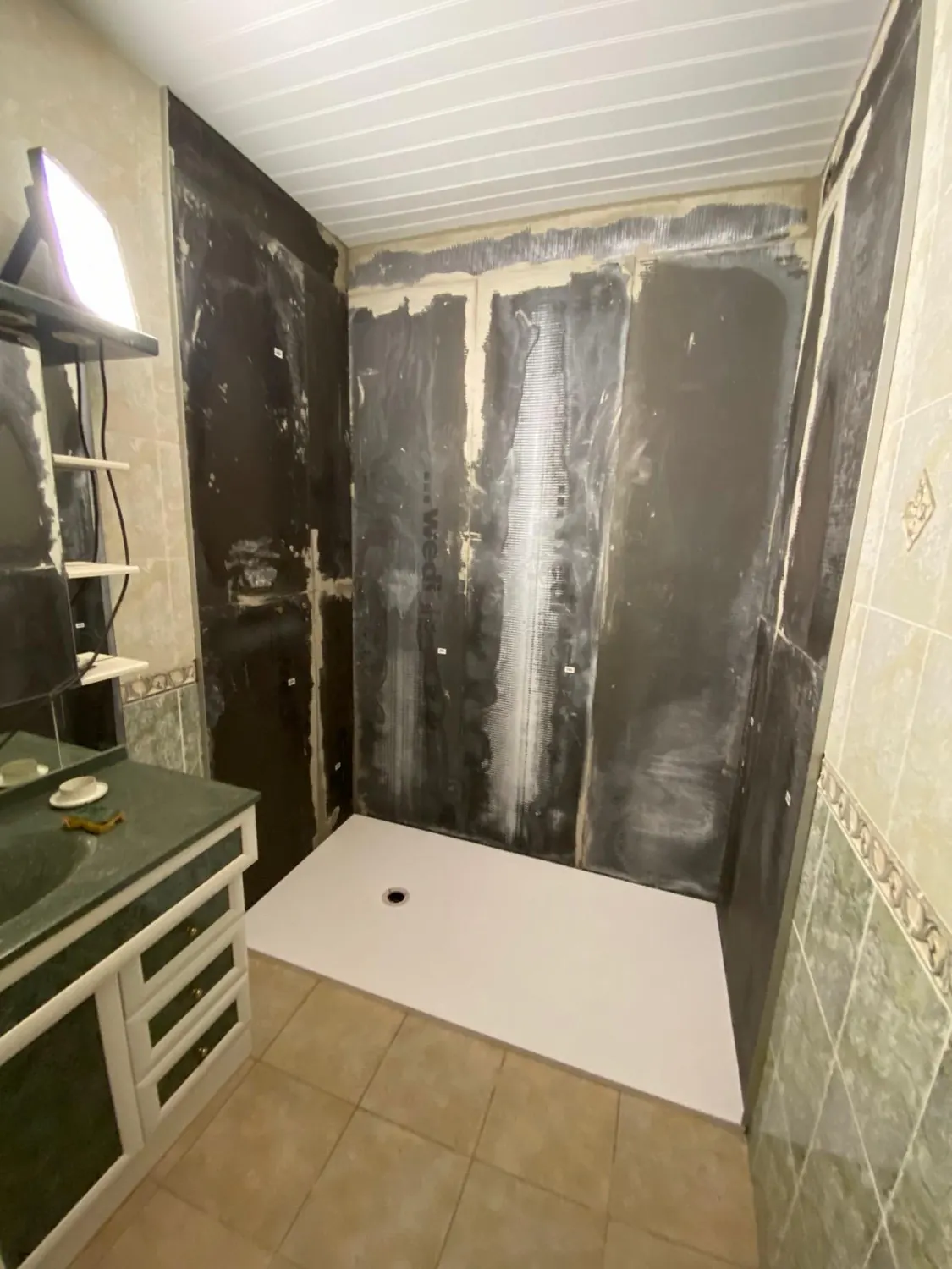 Douche en préparation avec panneaux d'étanchéité et receveur extra-plat