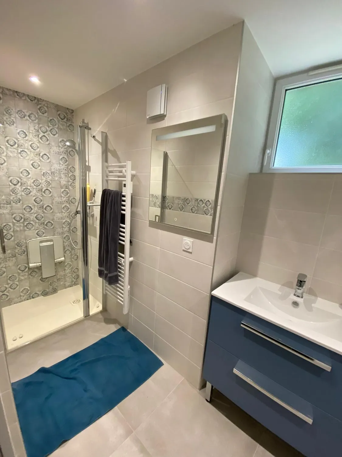 Salle d'eau avec douche à l'italienne et meuble vasque bleu
