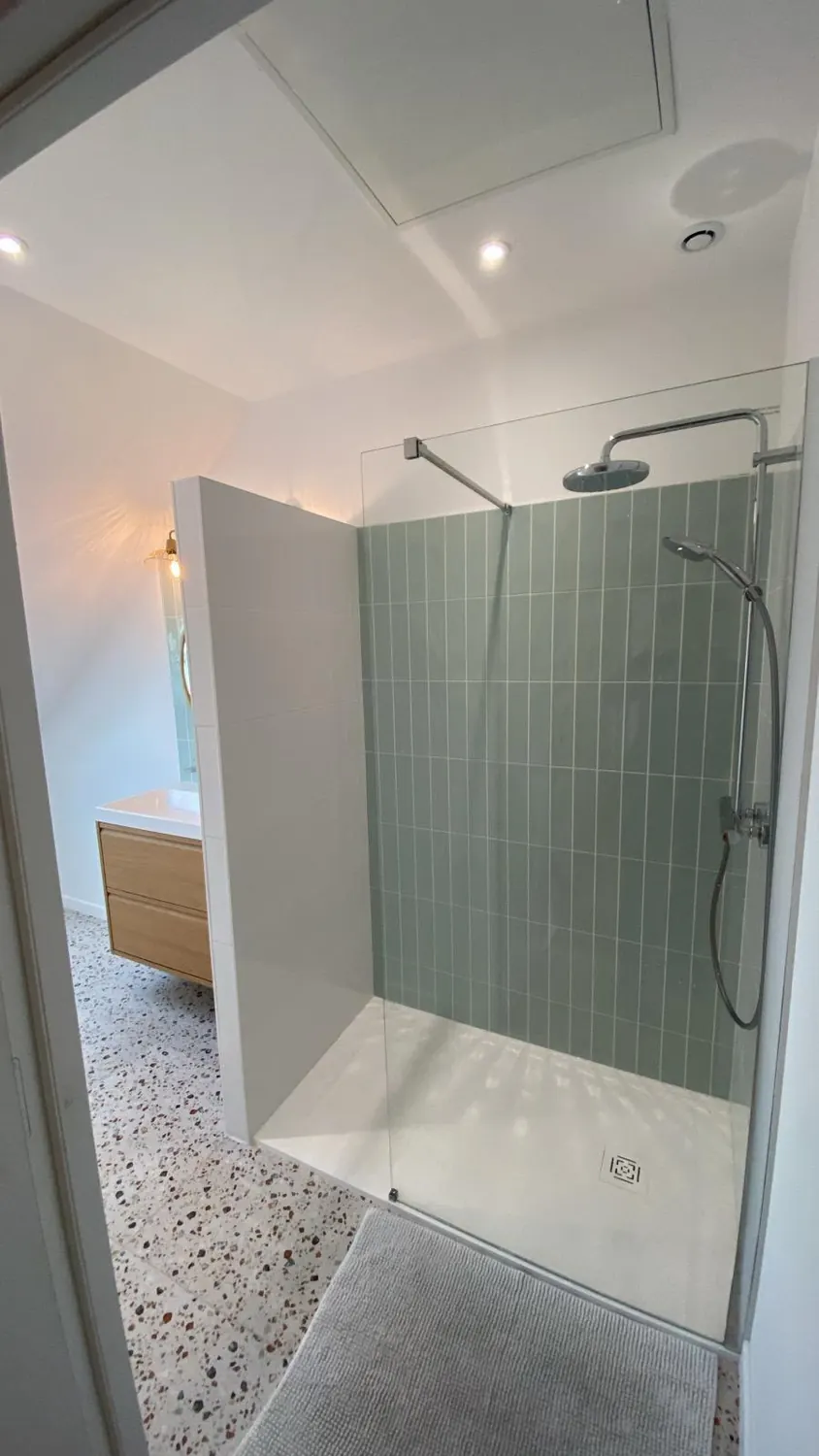 Douche à l'italienne avec faïence vert pâle et sol terrazzo