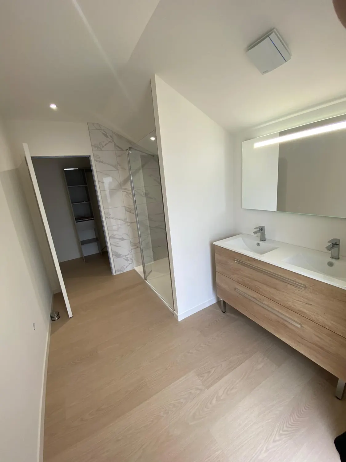 Salle d'eau avec double vasque suspendue en bois et parquet